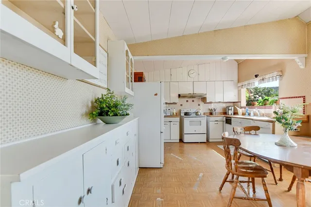 a kitchen with granite countertop white cabinets and white appliances