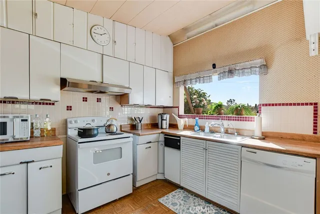 a kitchen with white cabinets sink and white appliances
