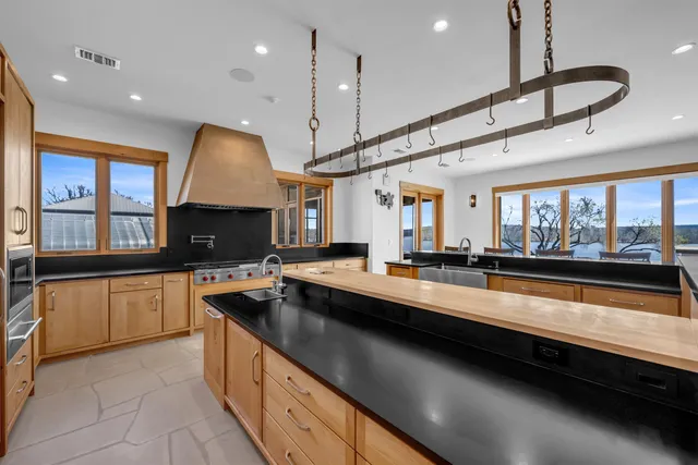 a large kitchen with stainless steel appliances lots of counter space and a sink