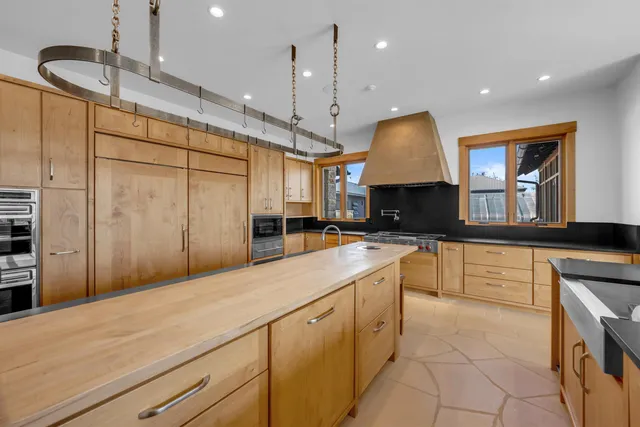 a kitchen with stainless steel appliances granite countertop a sink a stove and a refrigerator