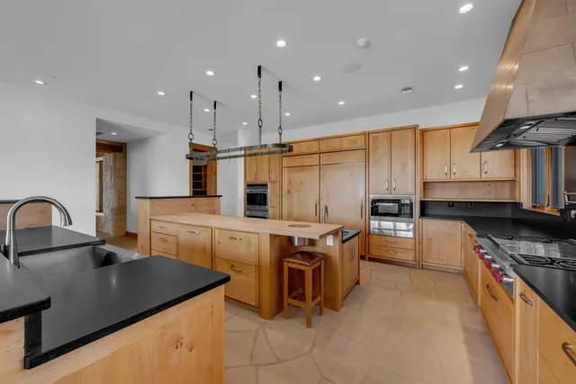 a kitchen with stainless steel appliances granite countertop a sink a stove and a refrigerator