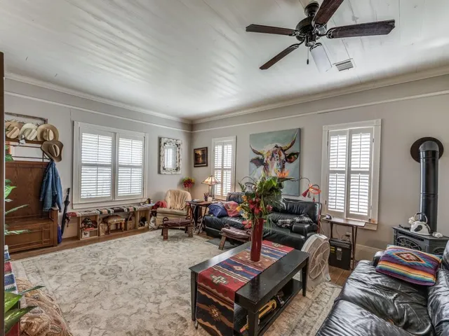 a living room with furniture a flat screen tv and a window