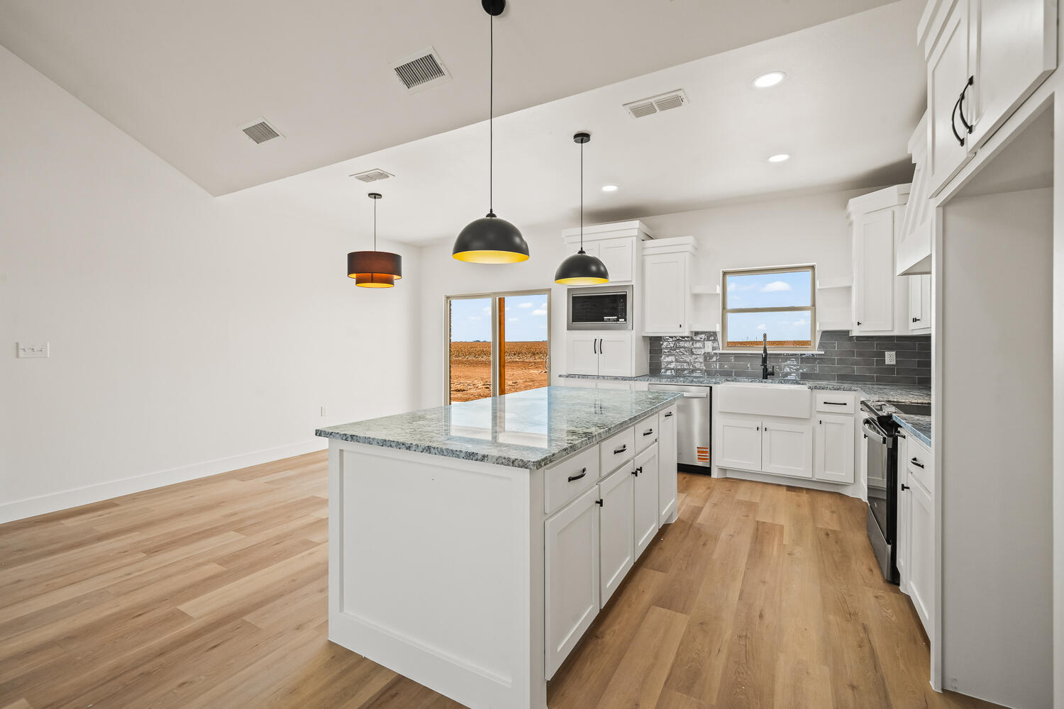 4062 Hawk Road Ropesville, TX 79358 - Photo 40 of 45 a large kitchen with stainless steel appliances kitchen island a large counter top a stove a chimney a sink and a refrigerator