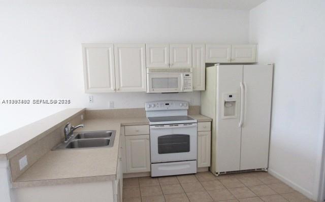 a kitchen with cabinets stainless steel appliances and sink