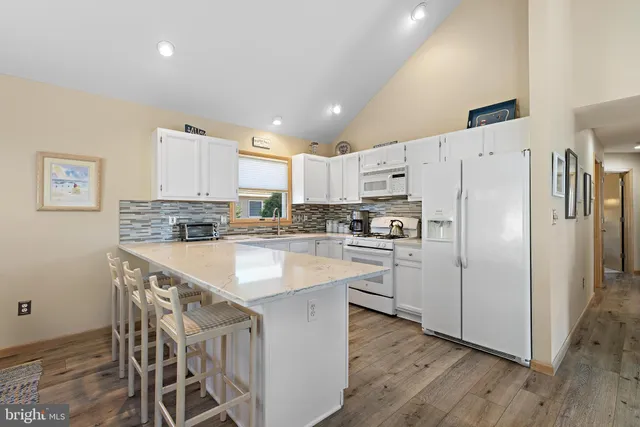 a kitchen with kitchen island white cabinets and stainless steel appliances