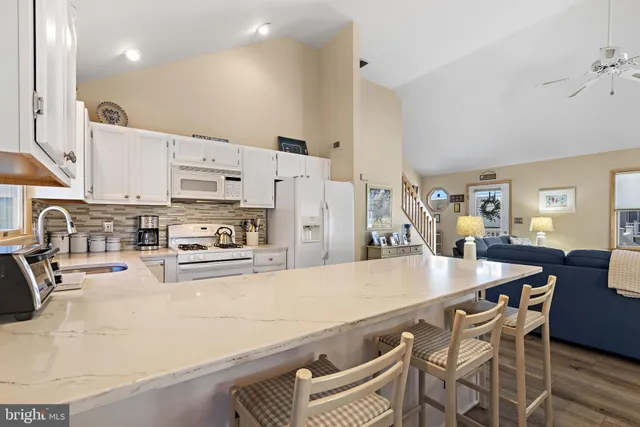 a large kitchen with stainless steel appliances lots of counter space and windows