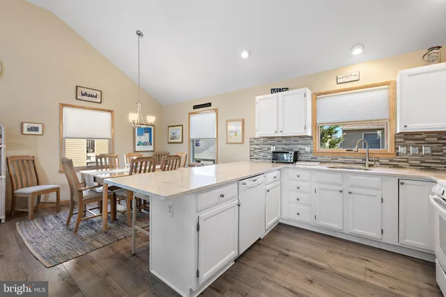 a open kitchen with stainless steel appliances granite countertop a stove and white cabinets