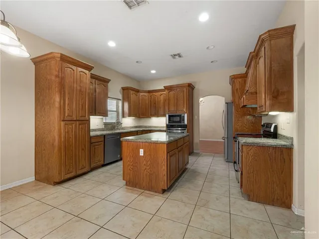 a kitchen with stainless steel appliances granite countertop a refrigerator and a sink