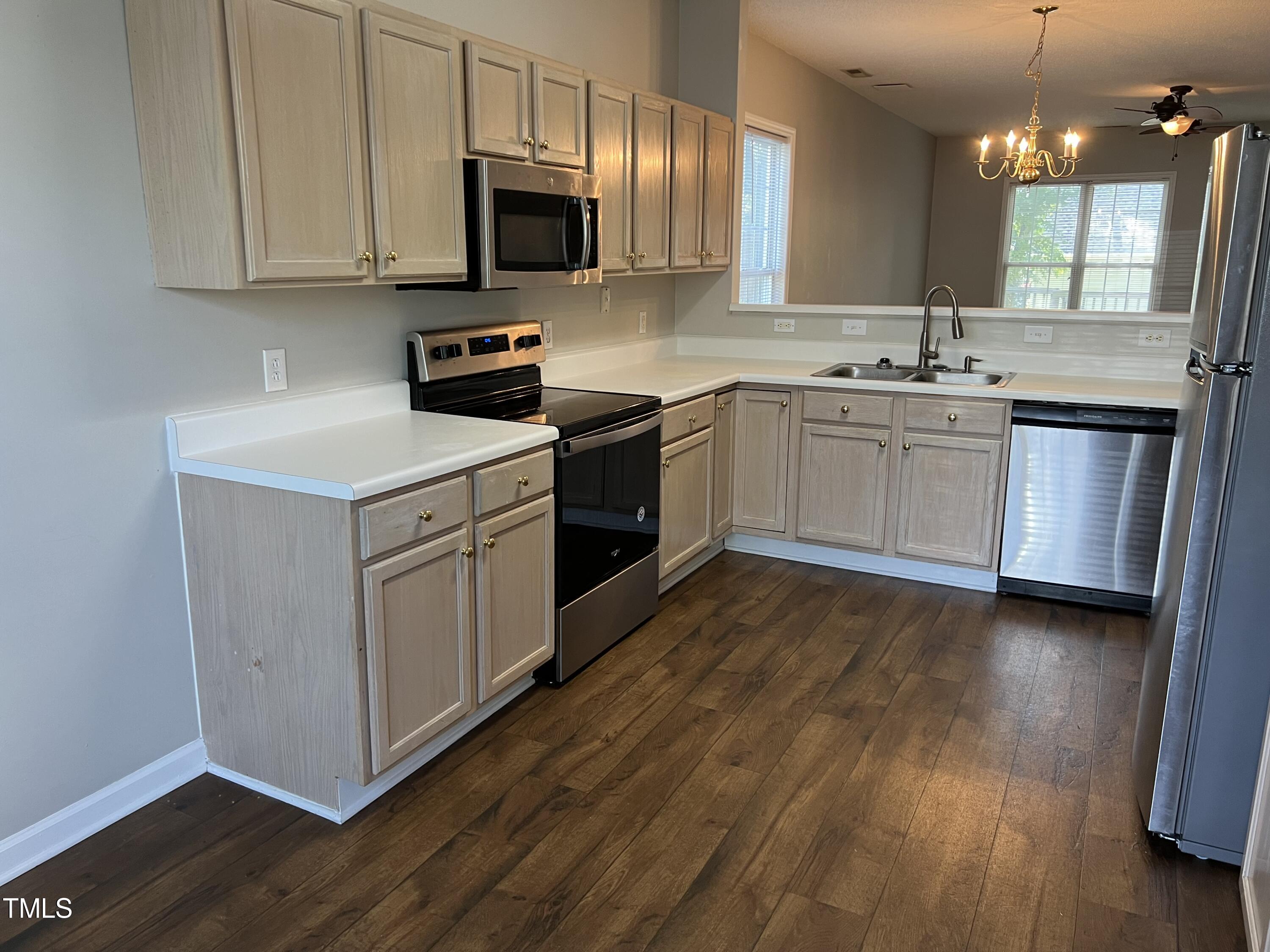 2032 Turtle Point Drive Raleigh, NC 27604 - Photo 8 of 18 a kitchen with a sink dishwasher a white stove refrigerator and cabinets with wooden floor