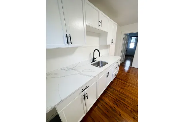 a hallway with sink and mirror