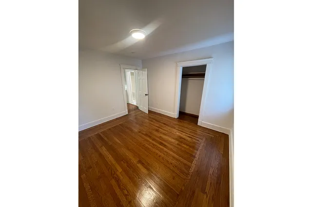 a view of a room with wooden floor and a window