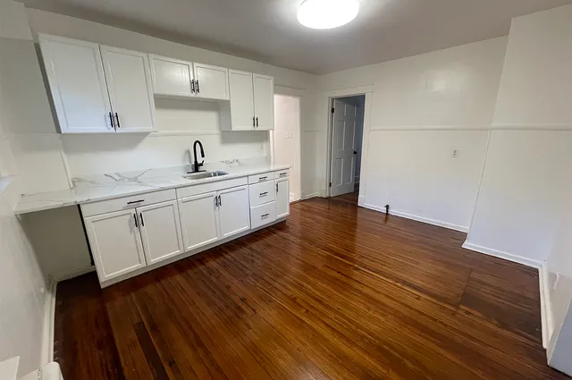a kitchen with wooden floors and cabinets