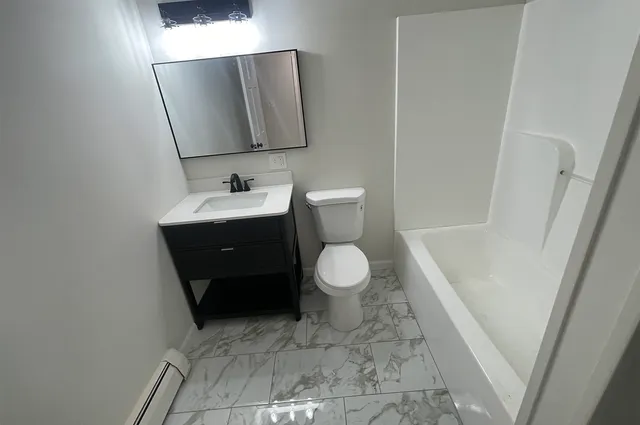 a bathroom with a toilet a sink and mirror