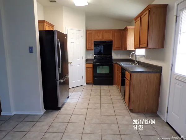 a kitchen with granite countertop white cabinets and stainless steel appliances