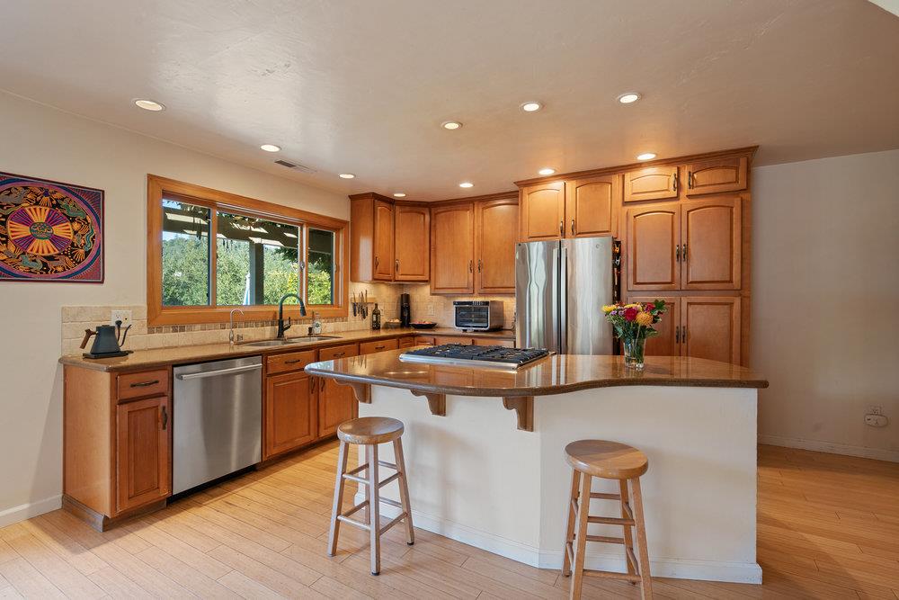 4760 Soquel Creek Road Soquel, CA 95073 - Photo 9 of 29 a kitchen with stainless steel appliances granite countertop a table chairs sink and wooden cabinets