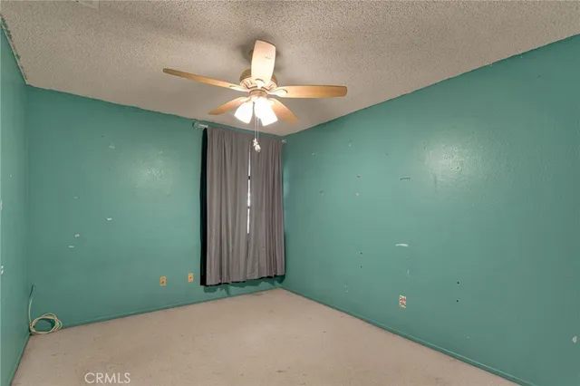 a view of a room that has a fan and hardwood floor