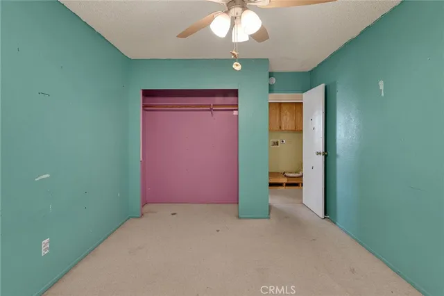 an empty room with a mirror and a fan