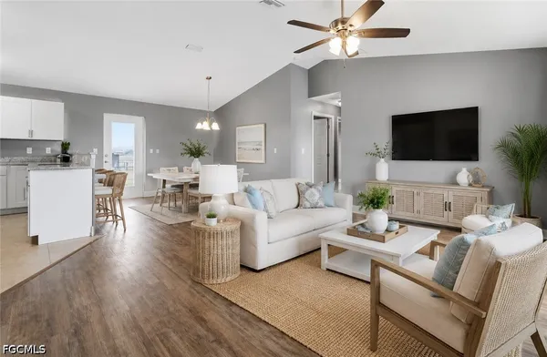 a living room with furniture a flat screen tv and a window