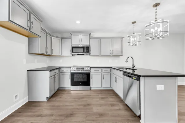 a kitchen with kitchen island granite countertop a sink cabinets and stainless steel appliances