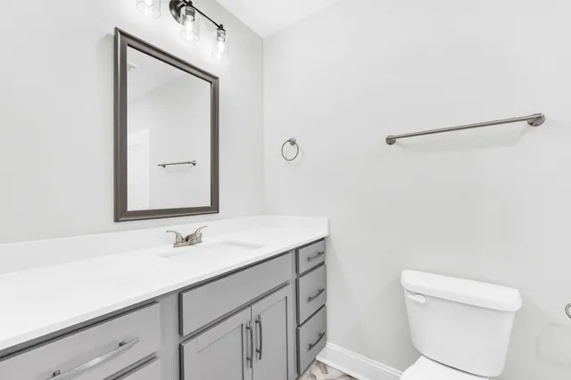 a bathroom with a sink a toilet and a mirror