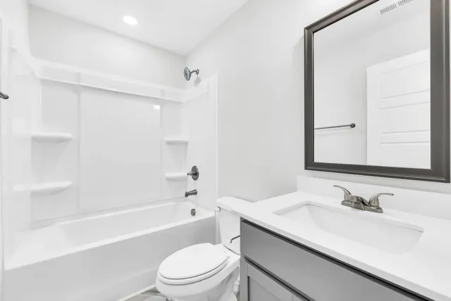 a bathroom with a granite countertop sink a toilet and shower