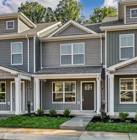 a front view of a house with a yard and potted plants