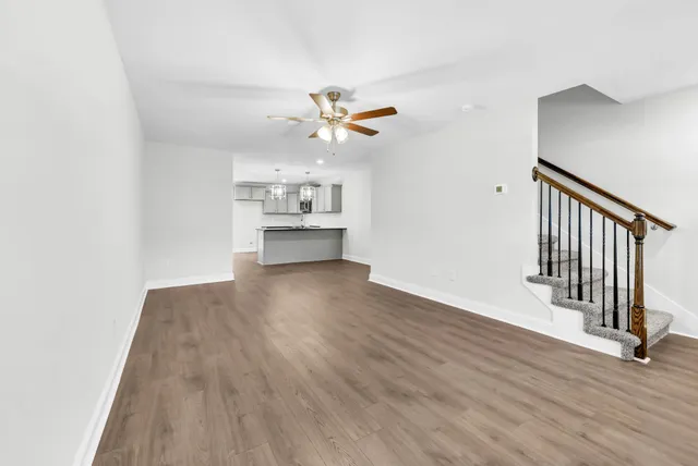 a view of a livingroom with wooden floor and a ceiling fan