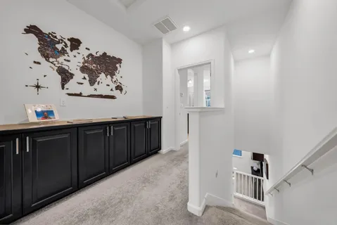 a view of a hallway with wooden floor and stairs