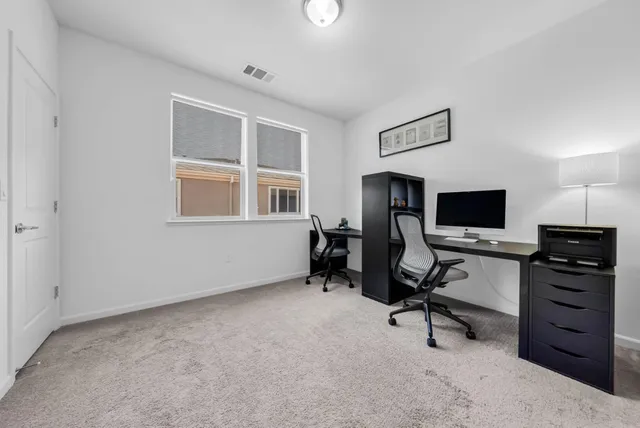 a view of a workspace with furniture and a window