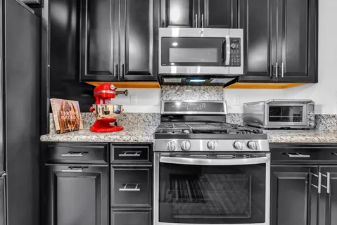 a kitchen with stainless steel appliances granite countertop a stove microwave and sink