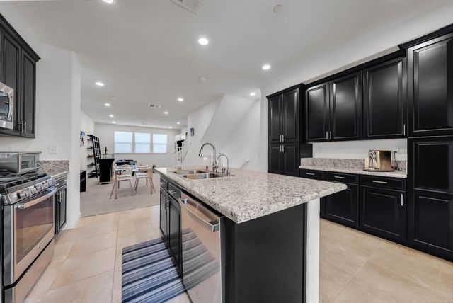 a kitchen with a stove a sink and a refrigerator