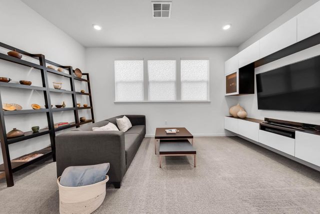 a living room with furniture a flat screen tv and a window