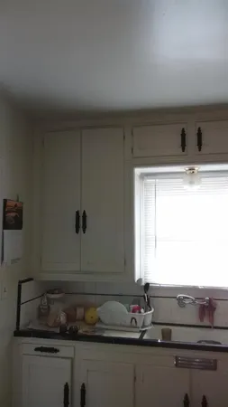 a bathroom with a granite countertop sink and window