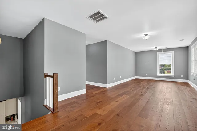 a view of empty room with wooden floor