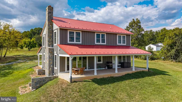 a view of a house with a yard patio and fire pit
