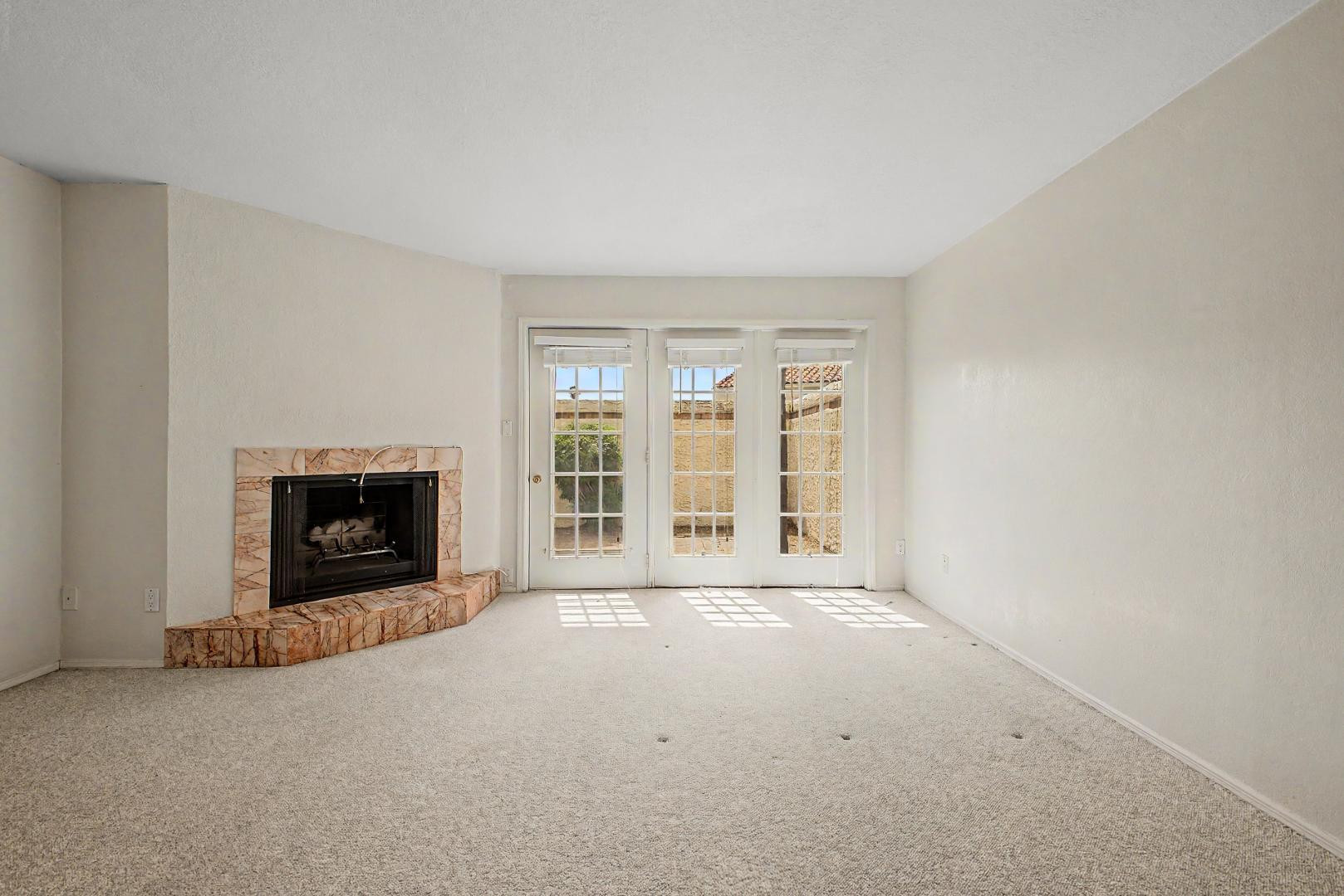 5736 North 25th Street Phoenix, AZ 85016 - Photo 11 of 59 an empty room with a fireplace and large windows