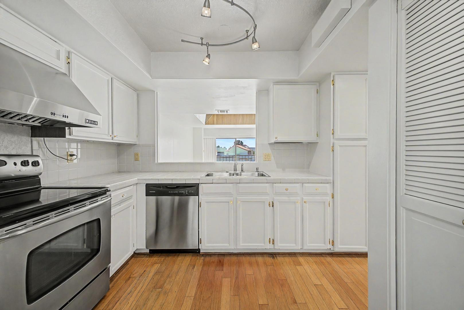 5736 North 25th Street Phoenix, AZ 85016 - Photo 5 of 59 a kitchen with stainless steel appliances granite countertop a stove a sink and white cabinets