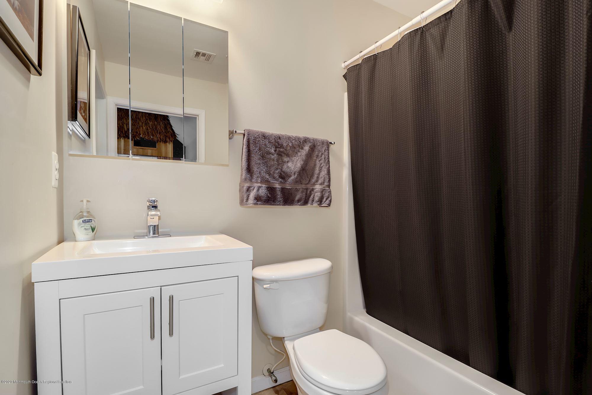 1403 Reed Road Cream Ridge, NJ 08514 - Photo 18 of 31 a bathroom with a toilet a sink and mirror