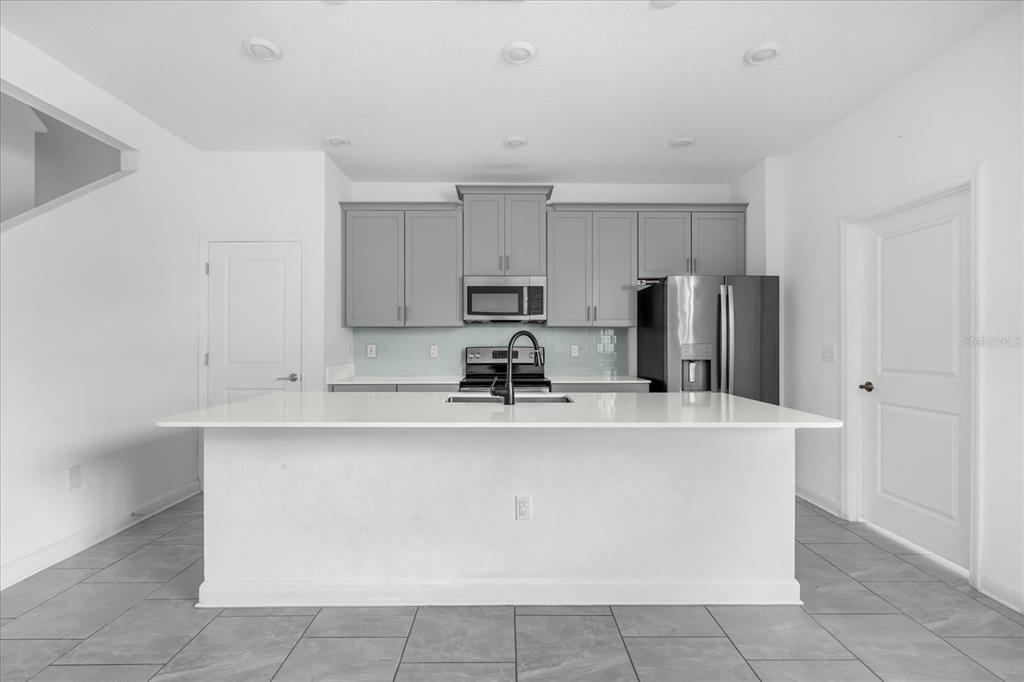 2959 Addison Boulevard St. Cloud, FL 34771 - Photo 4 of 30 a view of a kitchen with kitchen island a sink a refrigerator and a stove