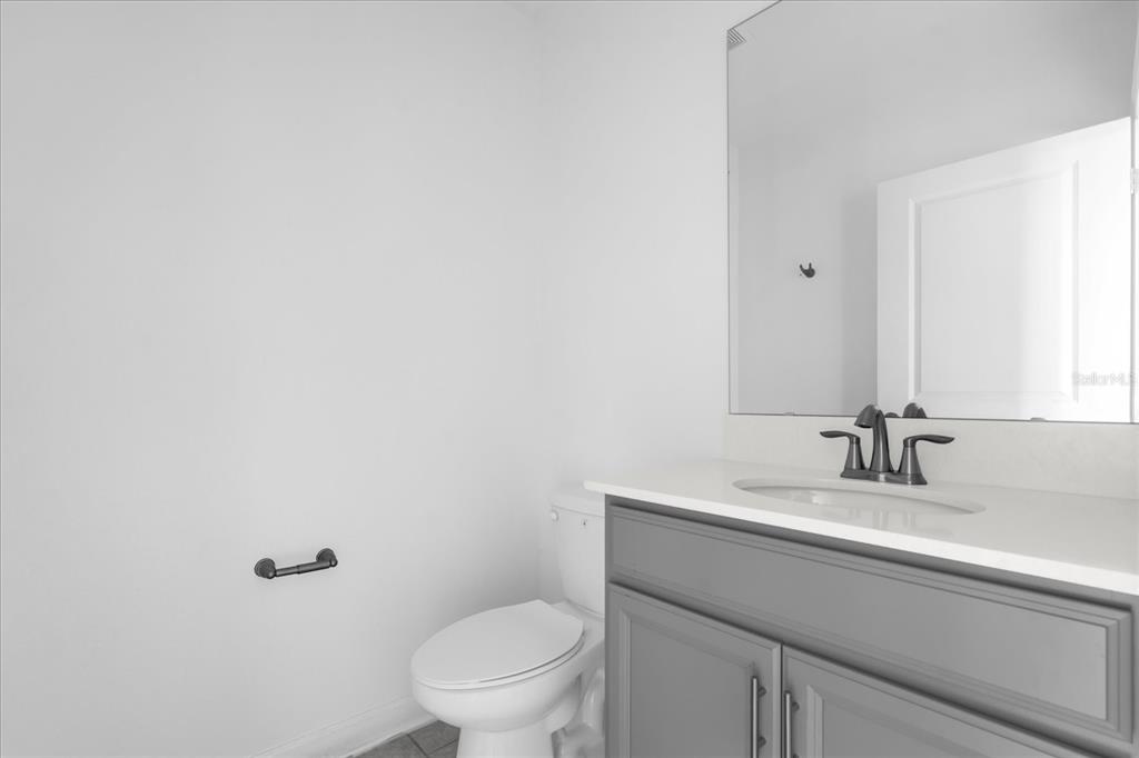 2959 Addison Boulevard St. Cloud, FL 34771 - Photo 8 of 30 a bathroom with a toilet a sink and mirror