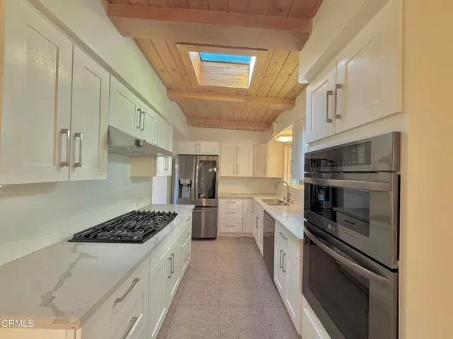 a kitchen with cabinets and a stove top oven