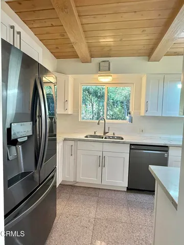a kitchen with stainless steel appliances a sink a stove a microwave and cabinets