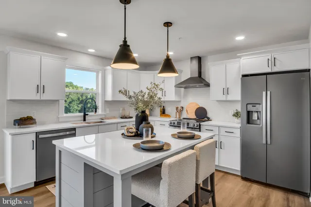 a kitchen with stainless steel appliances a stove a sink a window and cabinets