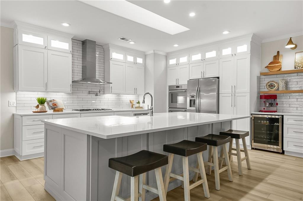 356 Shoal Creek Way Dallas, GA 30132 - Photo 3 of 32 a kitchen with stainless steel appliances granite countertop a table chairs sink and microwave