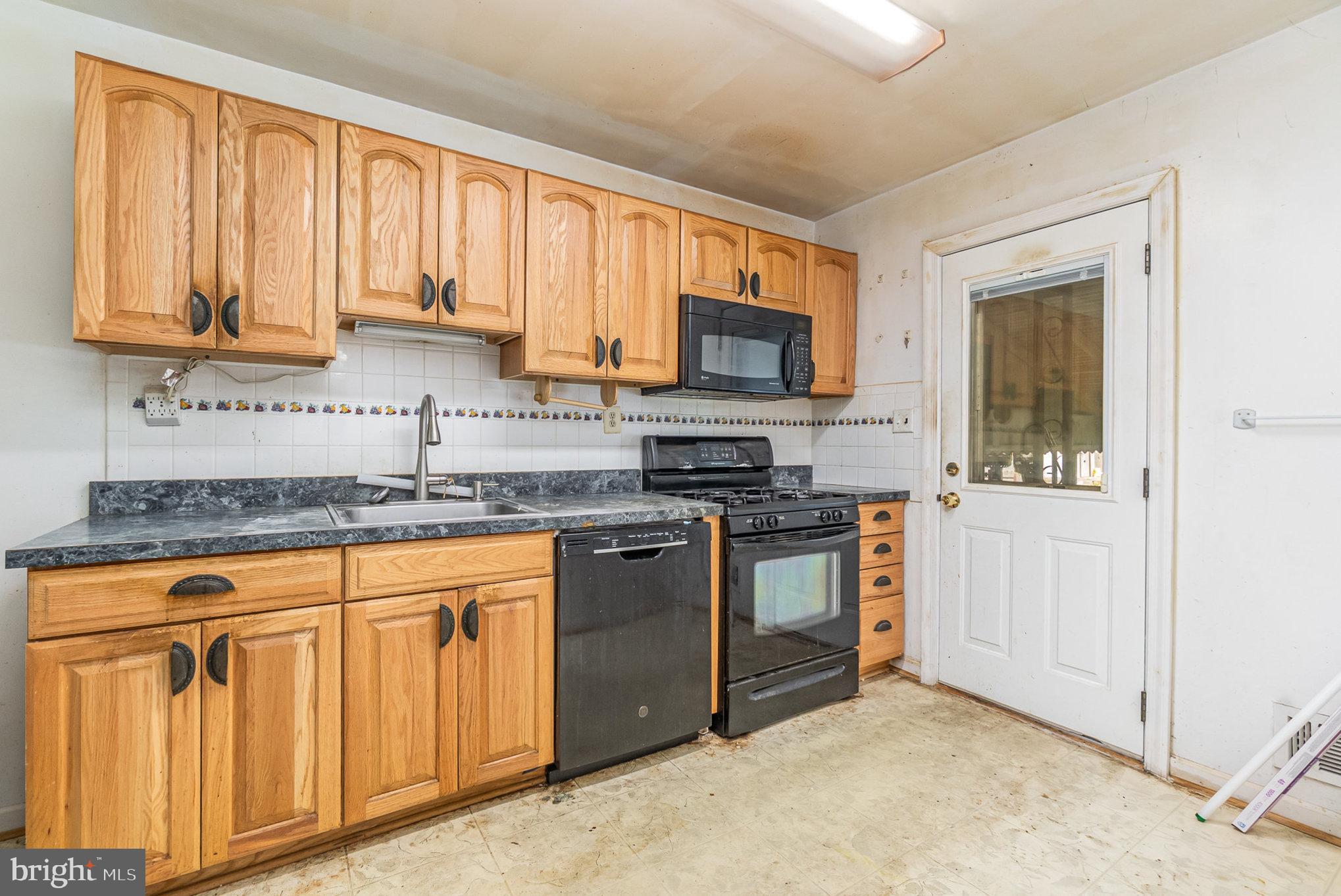 2137 Cockspur Road Baltimore, MD 21220 - Photo 8 of 25 a kitchen with stainless steel appliances granite countertop a stove a sink and a microwave