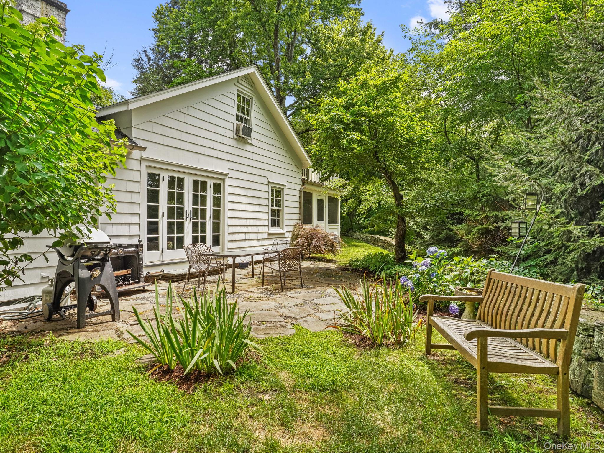 8 South Bedford Road Pound Ridge, NY 10576 - Photo 4 of 32 a view of a chair and table in the backyard