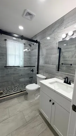 a bathroom with a double vanity sink toilet and mirror