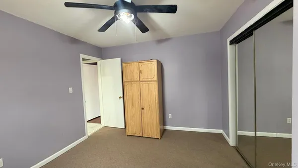 an empty room with chandelier fan
