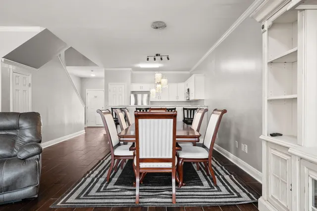 a kitchen with stainless steel appliances a white table chairs and a refrigerator