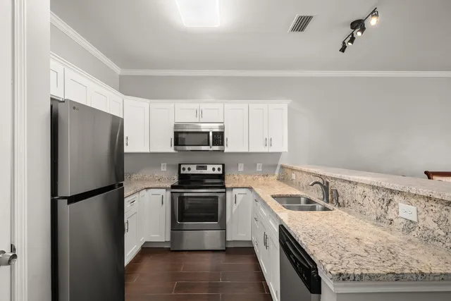 a kitchen with granite countertop white cabinets and sink